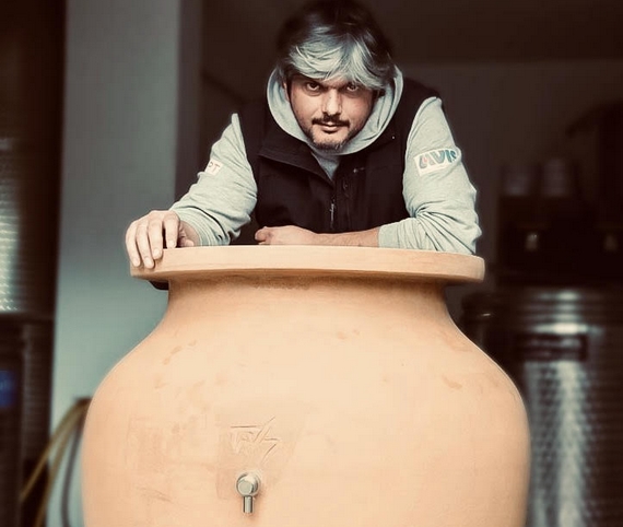 Il musicista vignaiolo Igor Delaiti accarezza un'anfora di terracotta (foto Benedetta Dolecki) itn 22 570.jpg